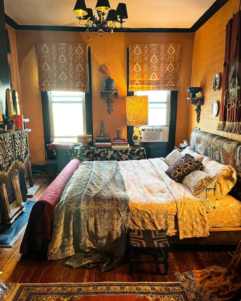 Boho maximalist bedroom with layered patterned bedding, warm mustard walls, eclectic decor, global-inspired textiles, and richly detailed accents creating a bold, cozy space.