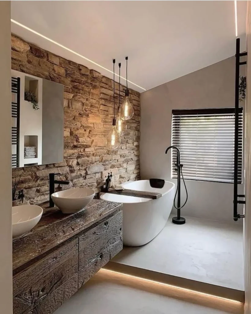 Industrial bathroom with exposed brick wall, rustic wood vanity, modern vessel sinks, freestanding bathtub, and black industrial fixtures.