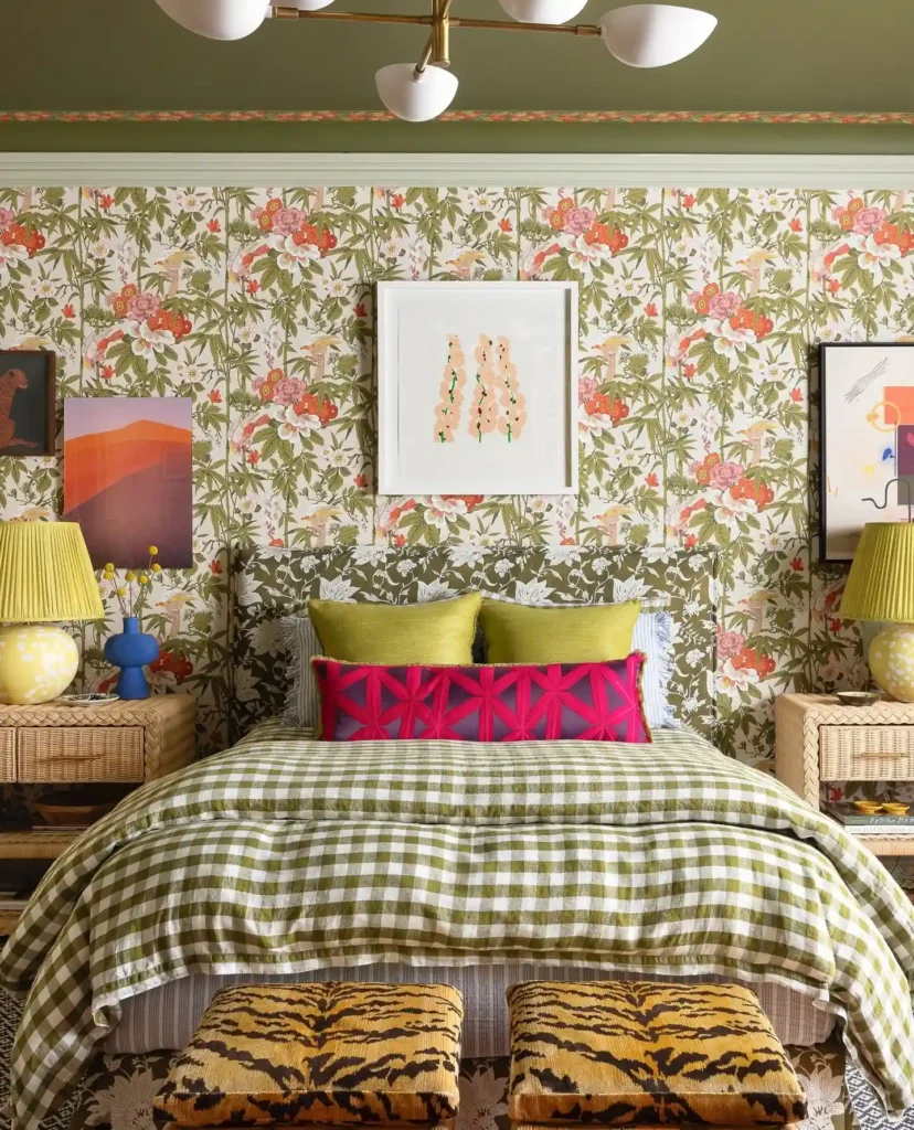 Funky bedroom wallpaper decor with bold floral print, green gingham bedding, and colorful accent pillows.