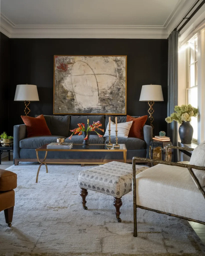 Elegant modern vintage living room featuring charcoal walls, abstract artwork, gray sofa, rust accent pillows, and gold coffee table.