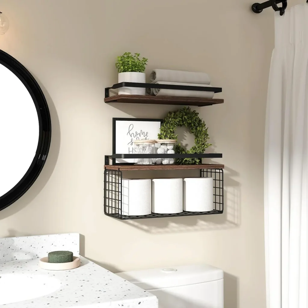 Wall-mounted wire basket bathroom shelf with wood floating shelves storing toilet paper, towels, and decor above toilet.