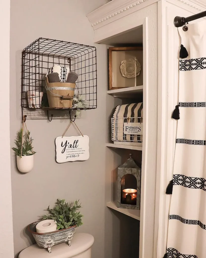 Farmhouse bathroom storage ideas with wire basket wall shelf, open shelving, black and white shower curtain, and rustic decor accents.