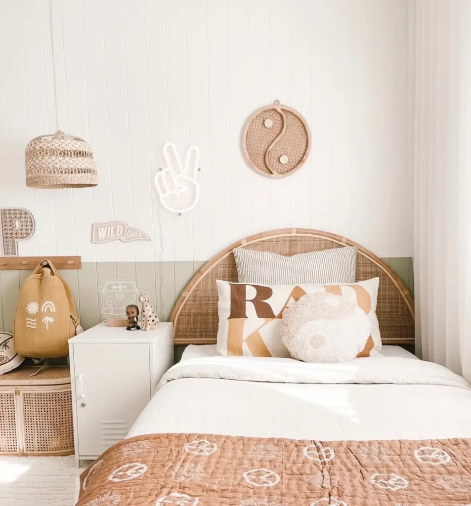 Coastal bedroom with a rattan headboard, woven wall art, rattan pendant light, and warm neutral bedding